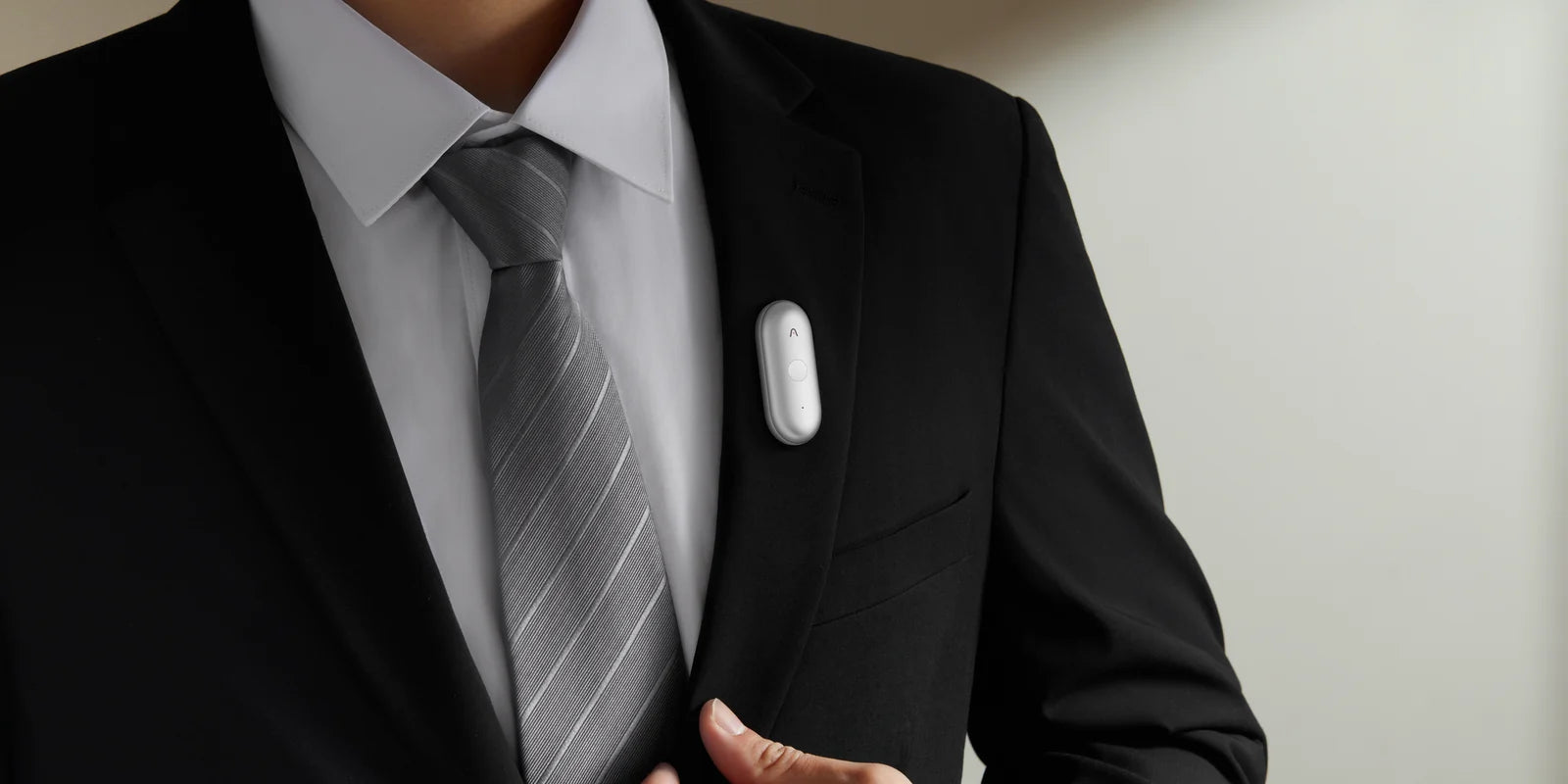 The Plaud NotePin S clipped to a suit jacket lapel. Photo via Plaud