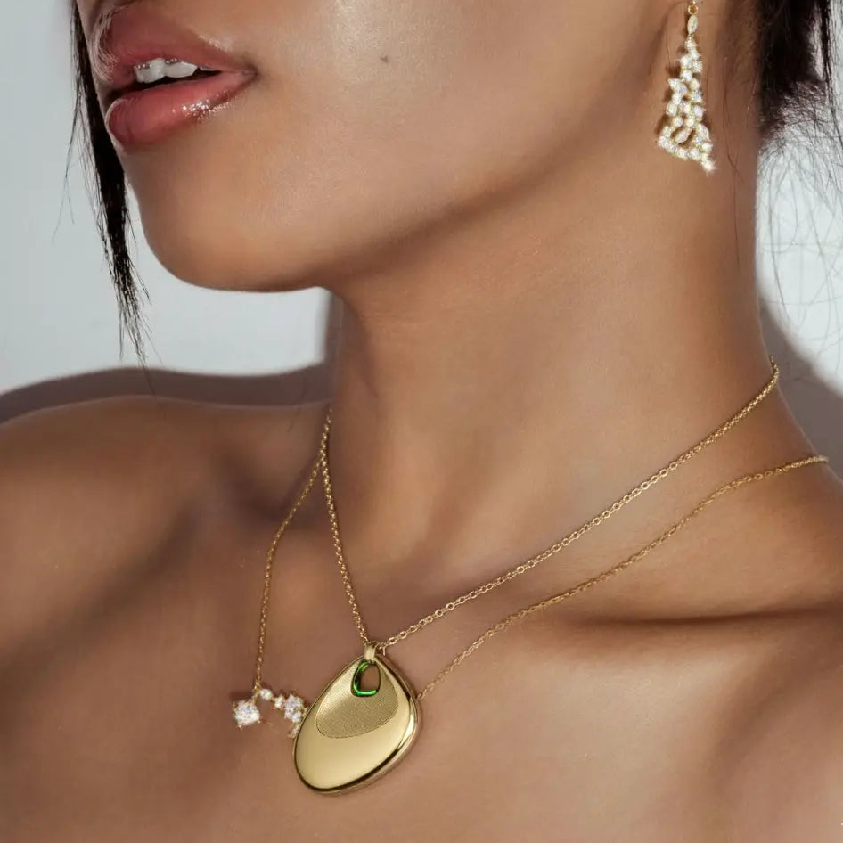 An AI necklace, also called an AI pendant, shown with its charging accessories