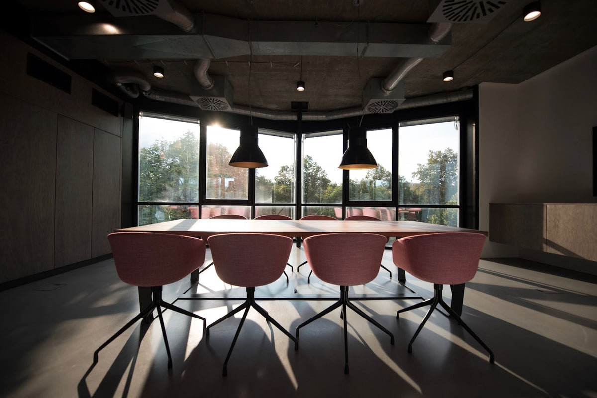 A team meeting around a table, the setting video meeting assistants were never built for