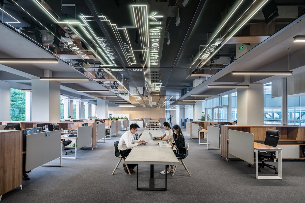Colleagues working together in an open plan office, the setting where an always-on pendant meets a company policy