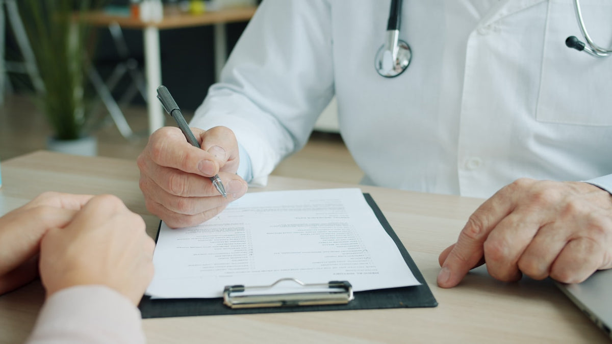 A clinician writing notes on a patient chart, the written record the patient does not go home with