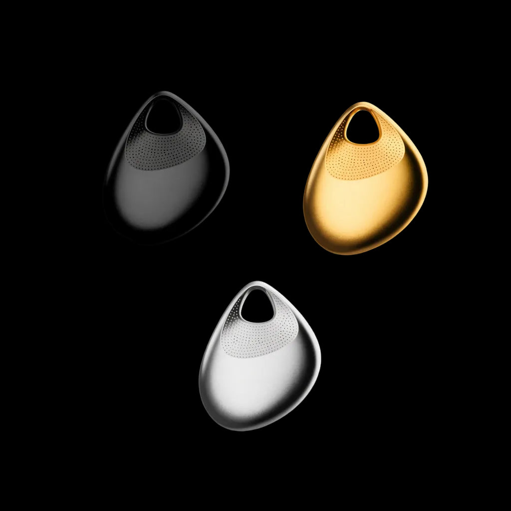 Three teardrop-shaped metallic earbud-style devices on a black background, shown in black, gold, and silver finishes.