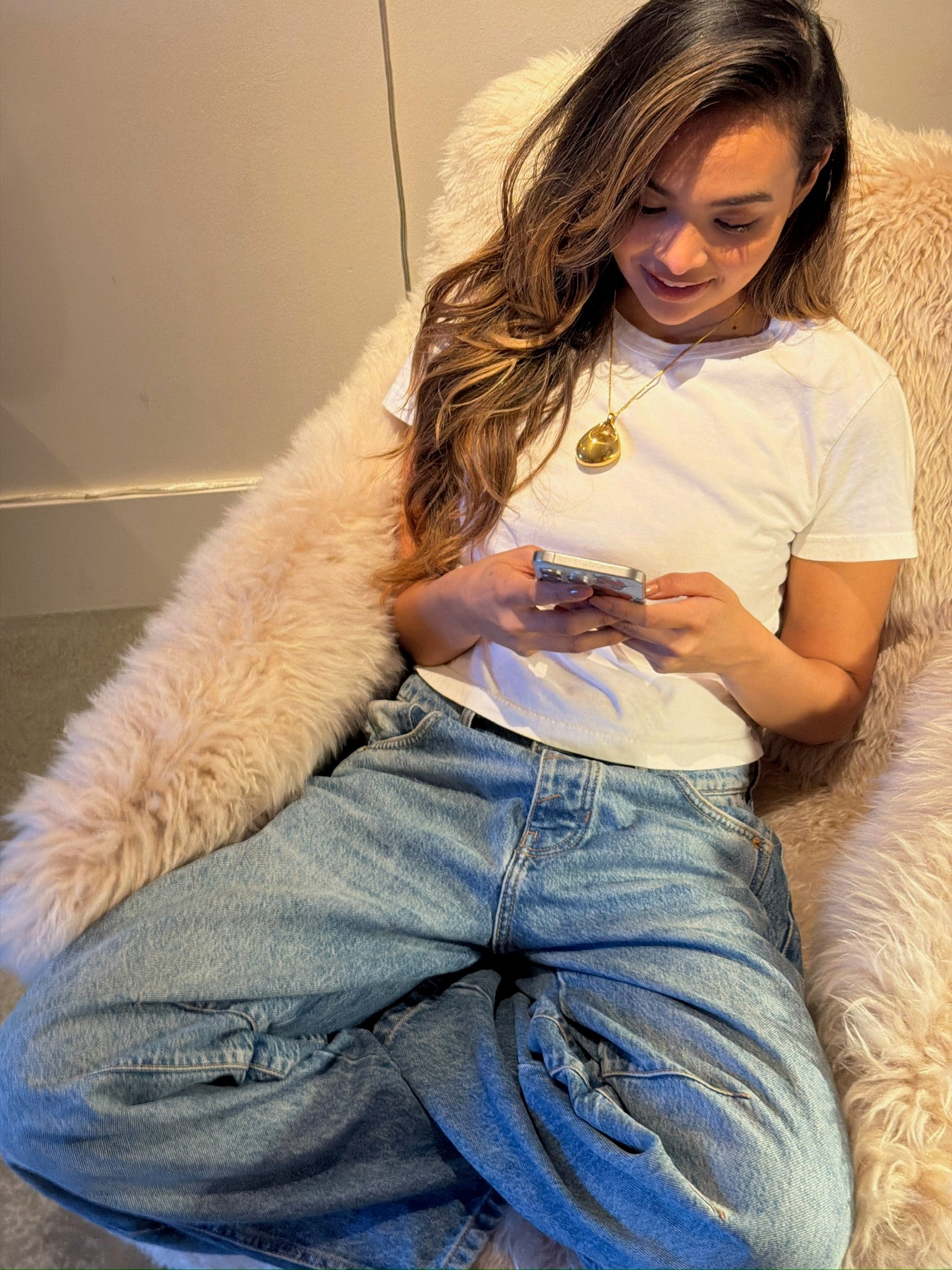 Woman wearing the LEGEND pendant, using the app